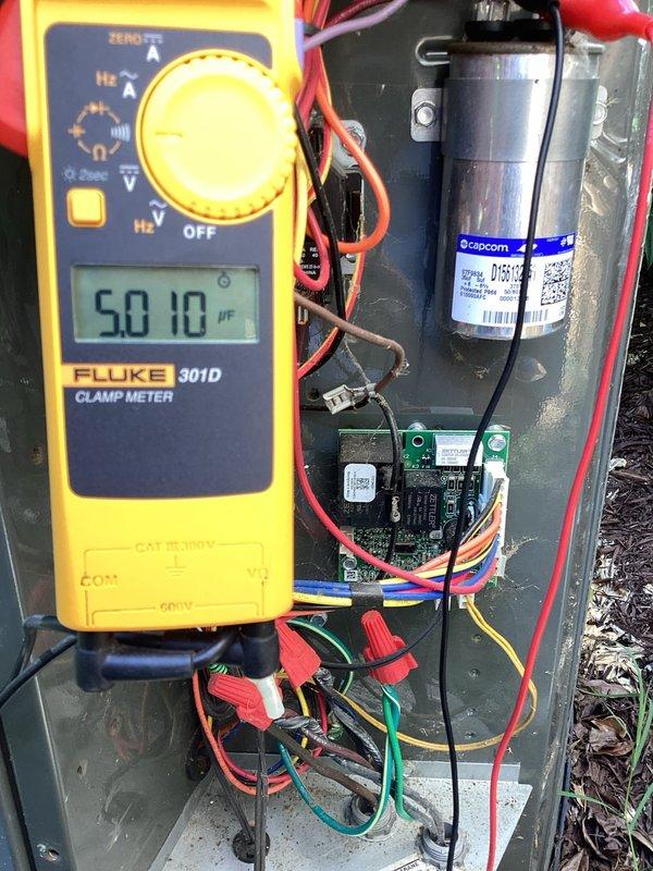 Responded to no-cool complaint on upstairs system experiencing extended runtime and poor cooling performance. Upon diagnostic evaluation, tested capacitor using clamp meter which displayed 50.10 μF reading, indicating capacitor failure below manufacturer specifications. Inspected contactor assembly and electrical connections for proper operation. System was running but unable to maintain temperature setpoint due to compromised capacitor affecting compressor efficiency.