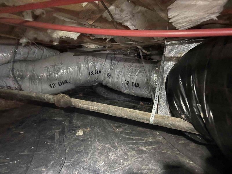 # HVAC System Temperature Differential Investigation

Responded to cooling system concern regarding temperature readings significantly below setpoint compared to multiple reference thermometers throughout the home. Performed comprehensive system inspection including attic and crawl space areas to assess HVAC ductwork, airflow distribution, and system operation. Documented existing ductwork configuration including 12-inch diameter flexible ducts, structural mounting, and installation conditions. Inspected accessible ductwork connections, insulation integrity, and potential air leakage points that could affect temperature consistency and system performance throughout the living spaces.