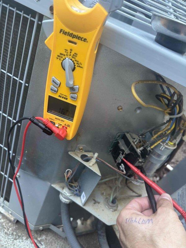 Responded to service call for upstairs system not maintaining temperature with hot air discharging from top of outdoor unit. Upon arrival, customer declined to power down system despite advisement that frozen coil conditions would prevent proper diagnosis and repair. Performed electrical diagnostics on outdoor condenser unit using clamp meter to test capacitor, contactor, and compressor circuits. Inspected indoor air handler and associated refrigerant lines in basement installation. Unable to complete full system evaluation or perform necessary repairs due to unit remaining energized and potential ice buildup on evaporator coil preventing access to refrigerant system components.