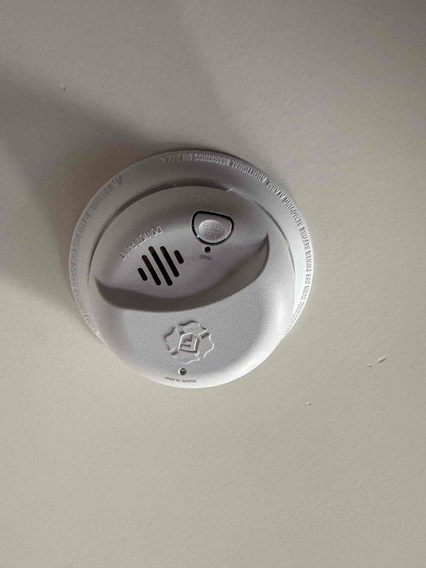 Completed installation of two ceiling fans in residential property with 8-foot ceilings, mounting one unit in the family room and one in the bedroom. Installed two hardwired smoke detectors with battery backup on ceiling surfaces, verifying proper placement per code requirements and confirming operational status through test button activation and LED indicator verification. All devices tested and left in full working order upon completion.
