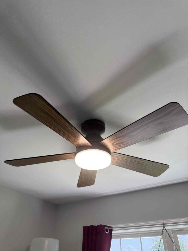 Completed ceiling fan upgrades in two separate rooms of the residence. Removed existing ceiling fan fixtures and installed new replacement units, including a five-blade model with wood-grain finish and oil-rubbed bronze housing with integrated light kit, and a four-blade contemporary model with dark wood-grain blades and cylindrical LED light fixture. Verified proper electrical connections, tested fan operation at all speeds, and confirmed light fixture functionality on both installations.