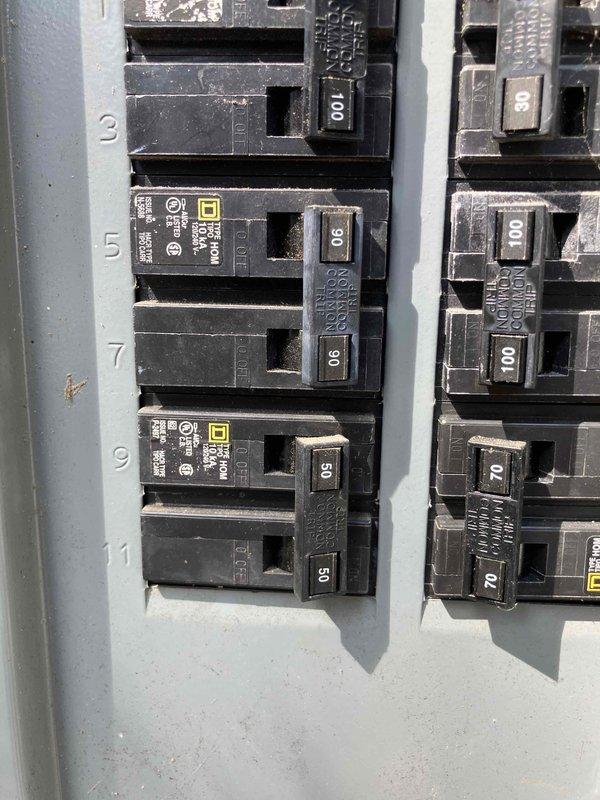 Inspected existing electrical panel in preparation for installation of new 90-amp breaker to feed sub-panel in crawl space. Work is pending arrival of the specified breaker, which may not have been ordered yet. Documented current panel configuration showing Square D load center with multiple circuit breakers ranging from 50 to 100 amps installed.