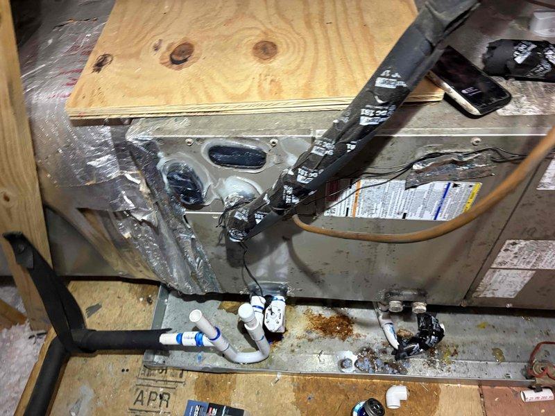 Responded to emergency service call for active water leak coming through ceiling from attic-mounted HVAC system. Upon arrival, found significant water accumulation under air handler unit. Performed thorough inspection of 6-year-old system, including blower assembly and condensate drainage system. Identified source of leak related to condensate drain line failure, evidenced by water staining on attic floor near PVC drain piping. Documented system condition with photos showing blower assembly, air handler configuration, and drainage components. Advised customer of findings and provided recommendations for repair to prevent further water damage and restore proper system operation.