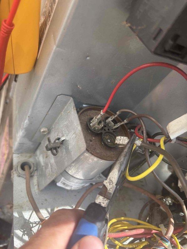 Responded to upstairs AC water leak complaint on 14-year-old system. Upon inspection, performed diagnostic testing of electrical components and condensate drain system. Tested capacitor connections and motor housing, noting corrosion present on metal components. Inspected condensate drain line and valve assembly for blockages or improper drainage. Used testing equipment to verify system operation and identify source of water leakage.