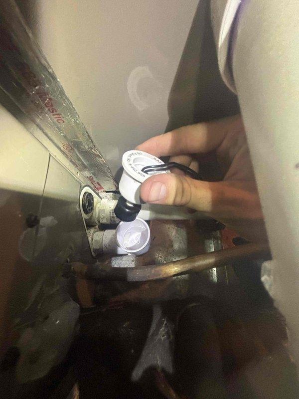 Responded to upstairs AC water leak complaint on 14-year-old system. Upon inspection, performed diagnostic testing of electrical components and condensate drain system. Tested capacitor connections and motor housing, noting corrosion present on metal components. Inspected condensate drain line and valve assembly for blockages or improper drainage. Used testing equipment to verify system operation and identify source of water leakage.