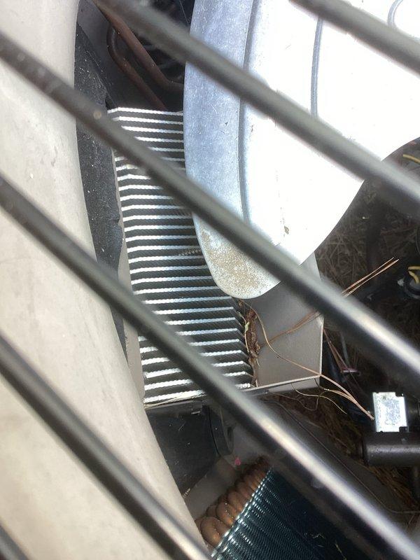 Responded to no cooling complaint on 8-year-old BOSCH system in 24-year-old residence. Upon inspection, discovered electrical issues stemming from recent lightning storm that caused power loss in living room and flickering outlets. Inspected outdoor condenser unit and heat exchanger coils through protective grating, documented equipment model and serial numbers. Customer reported previous diagnosis from another company recommending blower motor repair and was temporarily using three portable AC units causing circuit overload concerns.
