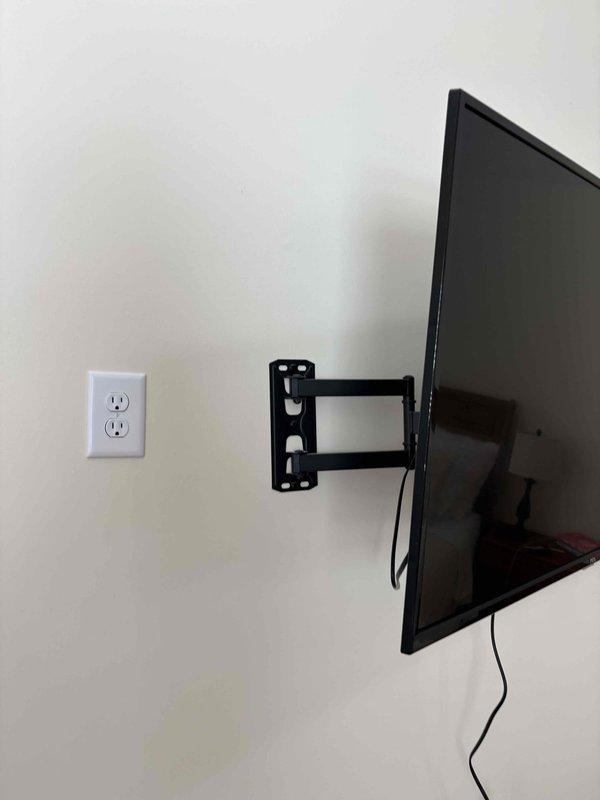Installed new electrical outlet in master bedroom to support wall-mounted television, verified proper voltage and grounding with circuit tester. Mounted flat-screen TV using articulating wall bracket with cable management along wall. Customer originally requested lighting installation in bedroom closet but proceeded with outlet installation for entertainment system instead.