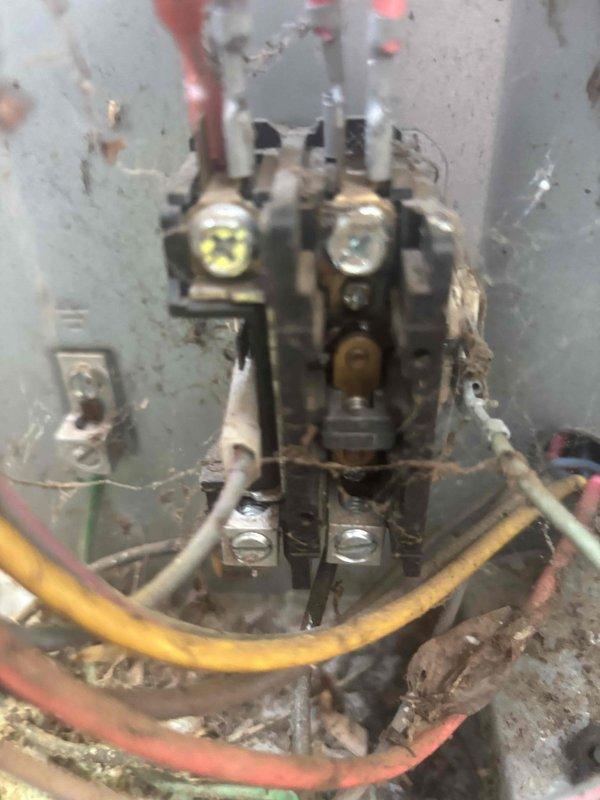 Responded to no cooling complaint on downstairs unit. Upon inspection, found aged outdoor unit with deteriorated electrical components, including heavily corroded contactor and wiring connections showing significant environmental wear and debris accumulation. Measured supply air temperature at 58.8°F, confirming insufficient cooling output. Documented equipment condition with photos showing extensive deterioration of electrical enclosure, paint degradation, and compromised wire connections requiring attention.