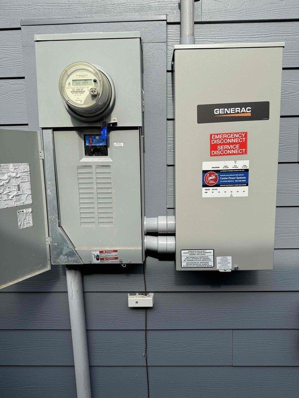 # Electrical Panel Surge Protector Service

Responded to service call for exterior surge protector displaying red indicator light and audible alarm. Inspected main electrical panel and associated equipment including meter base, Generac transfer switch, and whole-house surge protection device. Found surge protector had reached end of service life as indicated by red LED status indicator and alarm condition. The white rectangular surge protective device mounted in the main panel showed compromised MOV (metal oxide varistor) components, requiring replacement to restore proper surge protection to the electrical system. Verified all electrical connections, panel components, and grounding system were secure and functioning properly. Generator transfer switch and associated equipment operating normally with no issues detected.
