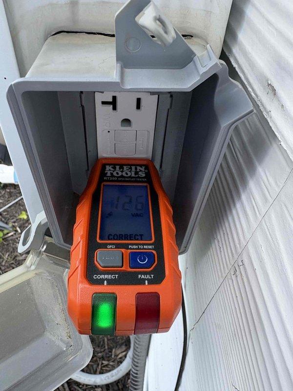 Responded to reported GFCI outlet issue at exterior garage location controlling pool lighting circuit. Performed comprehensive testing of weather-resistant GFCI receptacle using Klein Tools RT250 outlet tester, which confirmed proper voltage (12.1V reading displayed) and correct wiring configuration with functioning ground fault protection. GFCI outlet tested successfully with no faults detected, reset and test buttons operating within normal parameters, and weatherproof cover intact and properly sealed for outdoor installation.