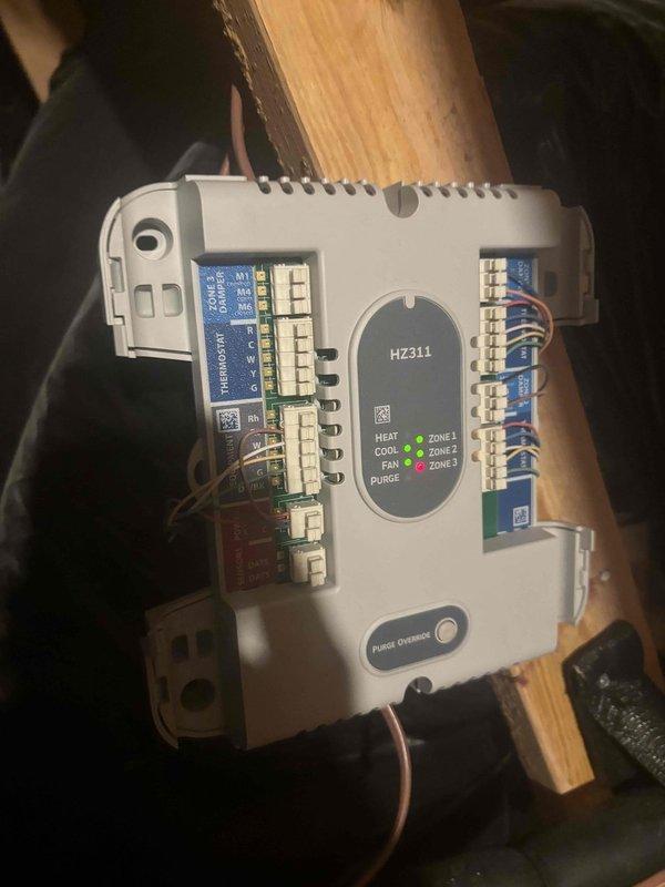 Responded to no cooling call where customer reported no air flow from vents and rising indoor temperatures. Upon arrival, found HZ311 multi-zone control board had been shut down by customer via thermostat. Inspected zone controller and verified proper wiring connections at terminal blocks, checked LED zone indicators for operational status, and measured supply air temperature at register reading 68.8°F. Restored system operation and confirmed airflow to affected zones.