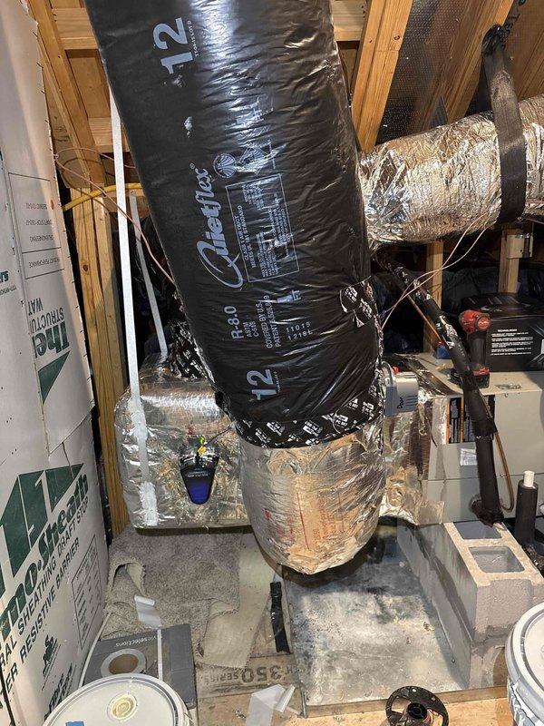 # HVAC Ductwork Installation

Completed installation of new insulated ductwork system in basement mechanical space, including black Quietflex flexible duct sections with reflective silver insulation connections. Installed and secured multiple duct runs through existing wooden framing structure, ensuring proper support and routing for optimal airflow distribution throughout the residence.