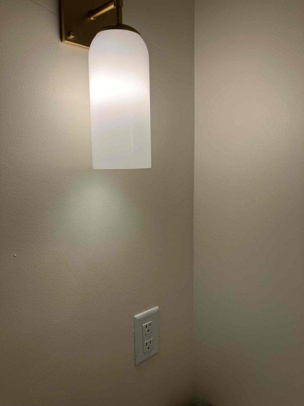 Completed bathroom electrical upgrade including installation of new switches and GFCI outlets with finished cover plates. Installed two customer-supplied vanity light fixtures with brass-toned sconces and frosted glass shades, along with a 4" slimline recessed can light above the shower area in the tiled enclosure. Supplied and installed a fire protection breaker to properly protect the multi-wire branch circuit serving the bathroom. All work completed to code with three-year warranty on parts and labor, extended to five years with membership enrollment.