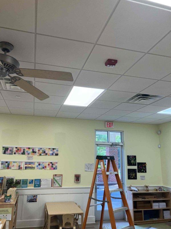 Responded to commercial facility for non-operational hallway lighting at approximately 10-foot ceiling height. Assessed recessed fluorescent light panels in drop ceiling grid system throughout interior corridor. Replaced failed lamps and verified proper illumination restored to all fixtures in affected hallway area.