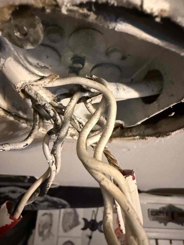 Responded to service call for ceiling fan installation assistance in bedroom of 1985 home. Customer had attempted DIY replacement but encountered confusion with wire connections. Upon arrival, inspected existing electrical junction box and wiring configuration. Found older electrical installation with multiple wire connections, including bundled white conductors and visible wire nuts in ceiling-mounted junction box. Wiring showed age-appropriate wear and discoloration consistent with original 1985 installation. Identified proper wire matching and connection sequence for new ceiling fan. Verified hot, neutral, and ground wire identification. Provided guidance on correct wiring configuration and connection methods. Ensured all wire nuts were properly sized and connections were secure. Confirmed electrical box mounting was adequate to support ceiling fan weight and operation. Installation assistance completed successfully with proper wire connections established.