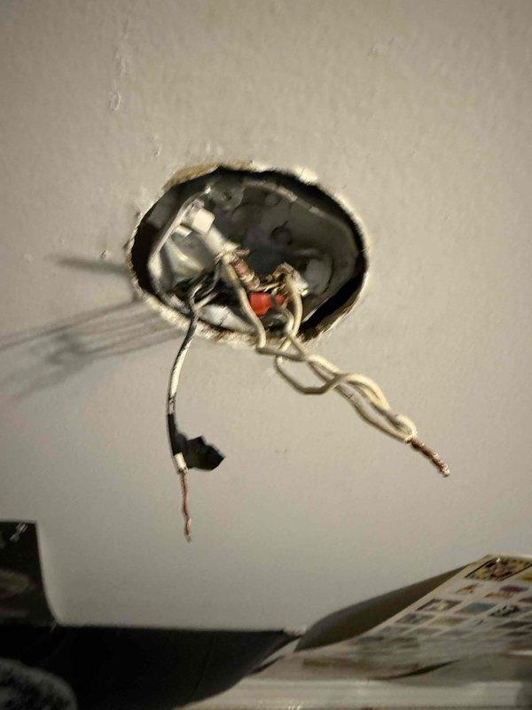 Responded to service call for ceiling fan installation assistance in bedroom of 1985 home. Customer had attempted DIY replacement but encountered confusion with wire connections. Upon arrival, inspected existing electrical junction box and wiring configuration. Found older electrical installation with multiple wire connections, including bundled white conductors and visible wire nuts in ceiling-mounted junction box. Wiring showed age-appropriate wear and discoloration consistent with original 1985 installation. Identified proper wire matching and connection sequence for new ceiling fan. Verified hot, neutral, and ground wire identification. Provided guidance on correct wiring configuration and connection methods. Ensured all wire nuts were properly sized and connections were secure. Confirmed electrical box mounting was adequate to support ceiling fan weight and operation. Installation assistance completed successfully with proper wire connections established.