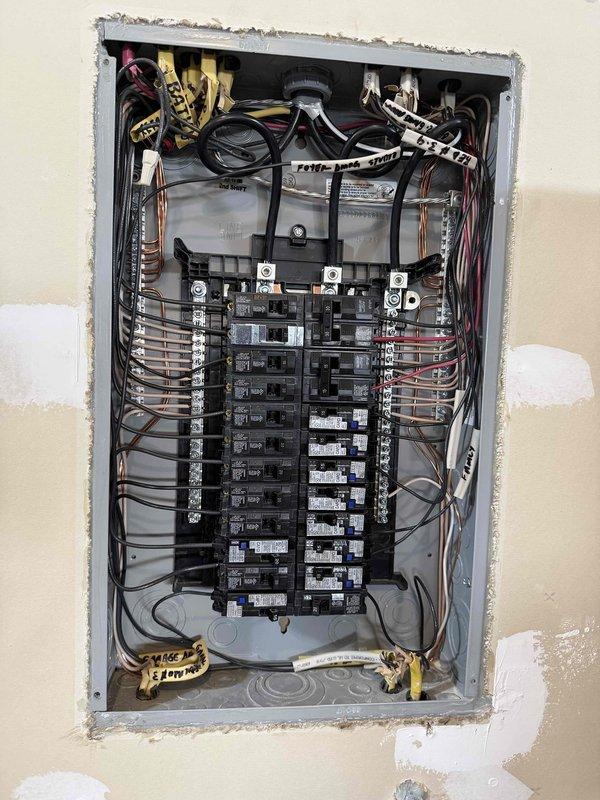 Responded to investigate intermittent breaker tripping issues affecting multiple circuits throughout a newly constructed residence with copper-clad aluminum wiring. Homeowner reported nuisance tripping on office circuit serving multiple desktop computers under load, as well as random tripping on bedroom lighting circuit with minimal load present. Performed comprehensive visual inspection of main electrical panel, examining all circuit breaker connections, bus bar terminations, and wire routing for proper installation per NEC standards. Inspected copper-clad aluminum conductor terminations at breaker connections for signs of overheating, loose connections, improper torque, or incompatible connection methods. Evaluated wire management throughout panel for code violations including excessive bending radius that could stress conductors or damage insulation. Verified proper breaker sizing relative to circuit wire gauge and connected loads. Documented panel configuration and wiring condition