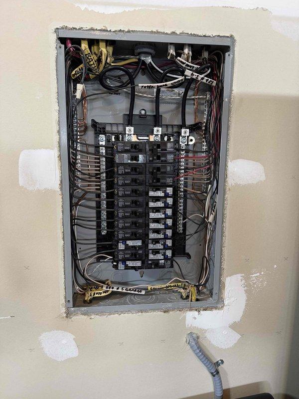 Responded to investigate intermittent breaker tripping issues affecting multiple circuits throughout a newly constructed residence with copper-clad aluminum wiring. Homeowner reported nuisance tripping on office circuit serving multiple desktop computers under load, as well as random tripping on bedroom lighting circuit with minimal load present. Performed comprehensive visual inspection of main electrical panel, examining all circuit breaker connections, bus bar terminations, and wire routing for proper installation per NEC standards. Inspected copper-clad aluminum conductor terminations at breaker connections for signs of overheating, loose connections, improper torque, or incompatible connection methods. Evaluated wire management throughout panel for code violations including excessive bending radius that could stress conductors or damage insulation. Verified proper breaker sizing relative to circuit wire gauge and connected loads. Documented panel configuration and wiring condition