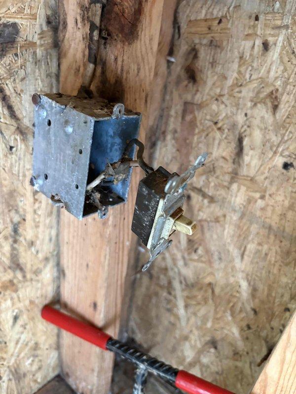 Responded to vacant property for two malfunctioning cellar lights. Upon inspection, discovered severely damaged electrical component with evidence of arcing, melting, and burn damage to switch or outlet box mounted on wooden framing—immediate safety hazard requiring replacement. Second issue involved porcelain pull-chain light fixture that would not shut off due to faulty internal socket mechanism. Documented both conditions with photographs and contacted property owner with findings and repair recommendations to address electrical hazards prior to property sale.