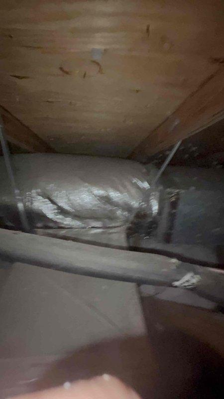 Responded to service call for air conditioning system not operating with drain pan collecting water. Accessed attic unit using extension ladder due to location over stairwell. Upon inspection, found condensate drain line clogged, causing primary drain pan to overflow and triggering float switch safety shutoff. Cleared drain line obstruction and verified proper drainage flow. Inspected air handler, ductwork, and return air filter. Restored system to normal operation and confirmed unit cooling properly with condensate draining as designed.