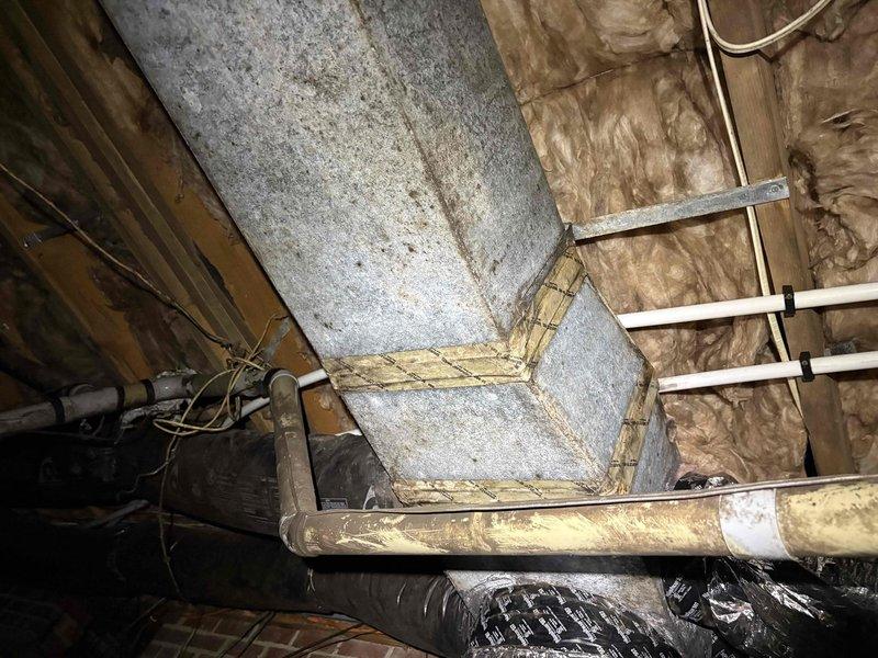 Responded to no cool complaint on an 8-year-old split system with reported reduced airflow described as "a little trickle." Upon arrival, performed full system evaluation including inspection of indoor air handler and ductwork system in attic space. Conducted visual inspection of supply ductwork, noting accumulated dust and debris on metallic duct surfaces, and examined insulation integrity and structural support components. Assessed airflow restrictions, checked filter condition, and inspected blower assembly operation. Verified refrigerant lines, condensate drainage, and electrical connections throughout the system. Evaluated duct sealing and connection points to identify potential air leakage contributing to inadequate cooling performance and reduced airflow to living spaces.