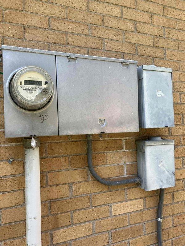 Completed installation of four outdoor light fixtures adjacent to entry door at standard ceiling height. Performed comprehensive electrical safety inspection of main service panel and residential branch circuit wiring, noting original 1971 electrical system components including meter base, main disconnect panel, and distribution equipment mounted on exterior brick wall. Documented existing electrical infrastructure condition and provided code compliance assessment for aging electrical system.
