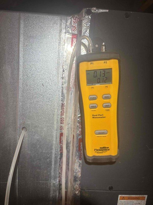 Responded to no cooling call on central air system experiencing intermittent shutdowns during mid-afternoon hours, requiring circuit breaker resets to restore operation. Performed diagnostic testing and measured static pressure at 0.12" w.c. on air handler unit, noting excessive condensation present on equipment cabinet. Inspected furnace combustion chamber and burner assemblies, documenting condition of ceramic fiber burner ports and igniter components. Addressed mold concerns in supply plenum as requested and evaluated system performance following previous capacitor replacement and air intake cleaning.