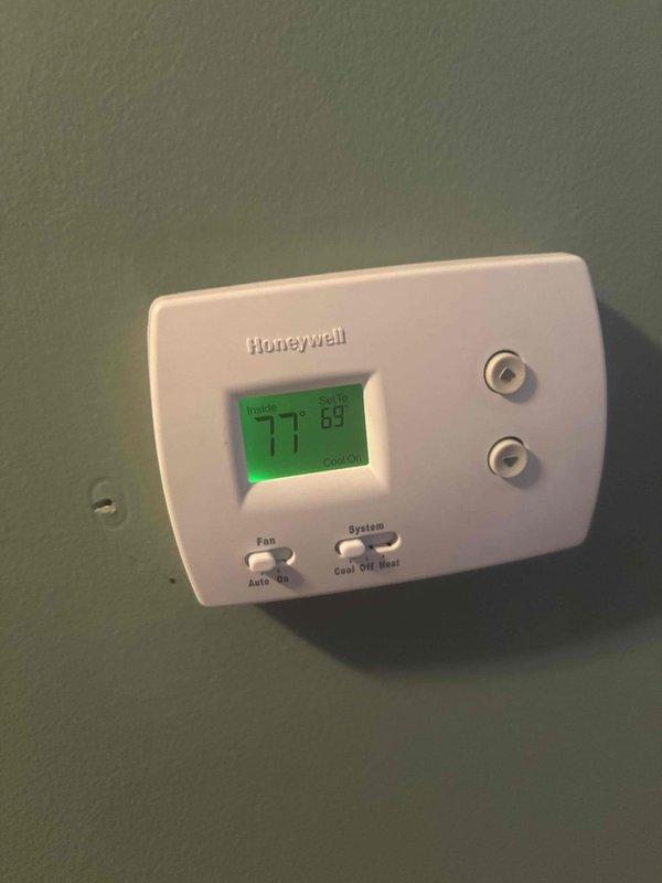 Responded to no cooling complaint on downstairs air conditioning unit in a two-system residence with 20-year-old equipment. Upon arrival, found thermostat displaying 77°F with system calling for cooling but unit not providing adequate temperature reduction. Inspected downstairs HVAC system located in basement utility area, evaluated unit operation, and assessed thermostat functionality to diagnose cooling failure.