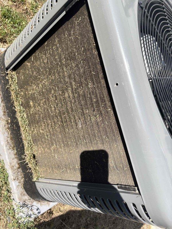 Responded to no-cooling complaint on recently installed residential air conditioning system at rental property. Upon arrival, found outdoor condensing unit with heavily clogged condenser coil and debris accumulation inside top panel, including leaves and organic matter restricting airflow. Documented excessive dirt and grass clippings on filter screen and coil surface, causing significant reduction in heat transfer efficiency and preventing unit from reaching setpoint temperature. Advised homeowner that system requires immediate cleaning and possible warranty evaluation due to recent installation. Recommended contacting property owner to review findings and determine appropriate corrective action.