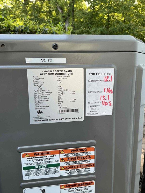 Responded to permit correction recall to address electrical breaker discrepancies for upstairs furnace system. Inspected electrical panel and identified dual breakers labeled for upstairs furnace, verified correct circuit assignment, and documented breaker specifications requiring correction from 25-amp to 16-amp rating. Also inspected and photographed A/C #2 heat pump outdoor unit, a Rheem variable speed R-454B system with documented field charge of 13.1 lbs total refrigerant.