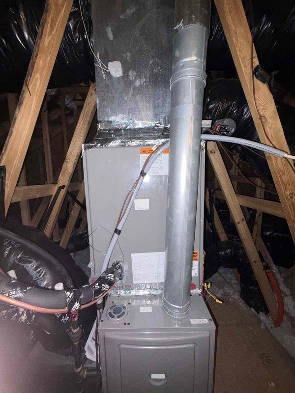 Completed full HVAC system installation in attic space consisting of Rheem Endeavor™ Line 3.5 ton 14.3 SEER2 condenser (Model RA14AY42AJ1NA) with R-454B refrigerant, 4 ton N-coil cased evaporator coil (Model RCFY4821STANMC) with TXV, and Classic 80% AFUE single-stage gas furnace (Model R801T0754A17UHSNAS) rated at 75,000 BTU with constant torque motor and standard NOx emissions. Mounted furnace unit on metal platform in attic with proper clearances and structural support. Connected metallic supply plenum and installed vertical main trunk ductwork extending from furnace. Ran and secured copper refrigerant line set between outdoor condenser and indoor evaporator coil. Installed black flexible return air ductwork to furnace intake. Completed all electrical connections including 208-230V single-phase power supply to condenser and low-voltage control wiring between units. Installed white PVC condensate drain lines with proper pitch and termination. Verified all gas connections to furnace wi