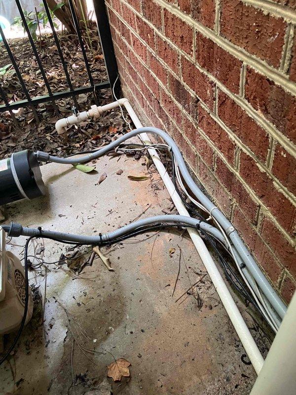 Responded to possible recall for tripping breakers at 1995 residential property with previous lightning strike history from 2024. Investigated reported issues with two salt system breakers and one booster breaker that were intermittently tripping. Verified power supply to daughter's ceiling fan and light fixture to determine if electrical circuit was functioning properly and providing adequate power to the fixture location. Documented exterior utility infrastructure and conduit routing along brick foundation for service records.