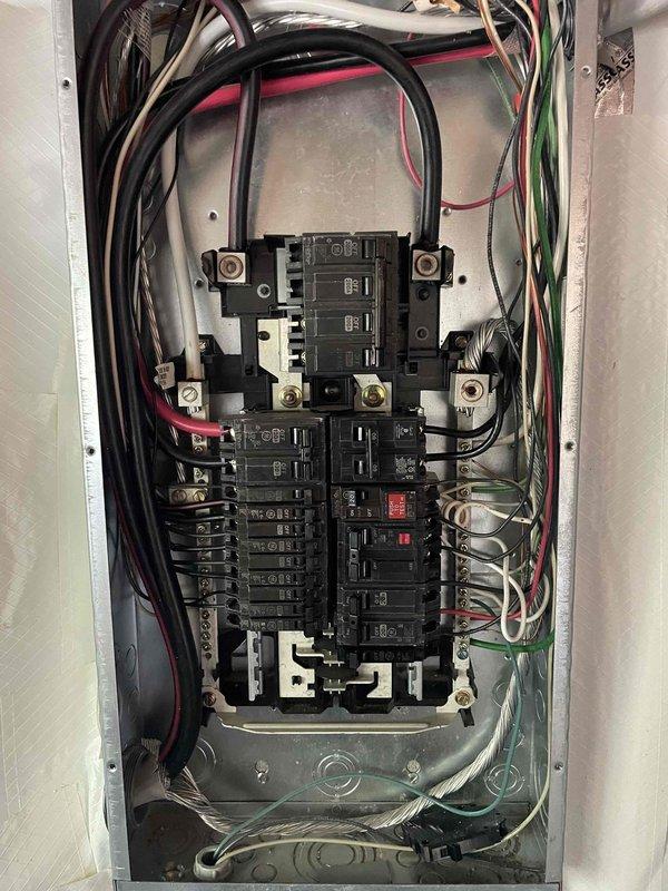 Responded to residential property built in 2006 to evaluate multiple electrical issues including flickering lights, non-functioning lighting circuits, and insufficient power capacity for electric vehicle charging equipment. Performed comprehensive electrical system inspection and diagnostic evaluation of the main service panel and exterior meter installation. Inspected interior circuit breaker panel, examining all branch circuit breakers, neutral bus bars, grounding connections, and conductor terminations for proper installation and signs of deterioration. Evaluated exterior electrical service equipment including digital meter, main disconnect, weatherproof junction boxes, and associated conduit connections. Identified electrical deficiencies contributing to reported flickering and inadequate circuit capacity. Documented panel configuration and existing electrical infrastructure with photographs. Provided homeowner with detailed findings and presented options for resolving identified e