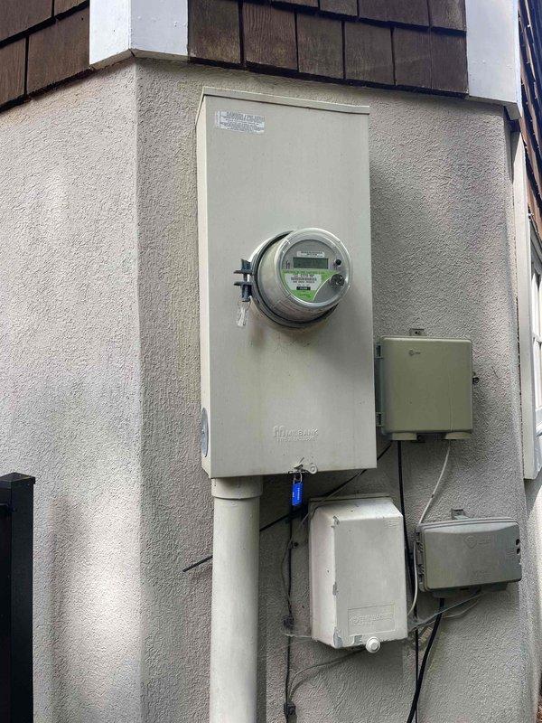 Responded to residential property built in 2006 to evaluate multiple electrical issues including flickering lights, non-functioning lighting circuits, and insufficient power capacity for electric vehicle charging equipment. Performed comprehensive electrical system inspection and diagnostic evaluation of the main service panel and exterior meter installation. Inspected interior circuit breaker panel, examining all branch circuit breakers, neutral bus bars, grounding connections, and conductor terminations for proper installation and signs of deterioration. Evaluated exterior electrical service equipment including digital meter, main disconnect, weatherproof junction boxes, and associated conduit connections. Identified electrical deficiencies contributing to reported flickering and inadequate circuit capacity. Documented panel configuration and existing electrical infrastructure with photographs. Provided homeowner with detailed findings and presented options for resolving identified e