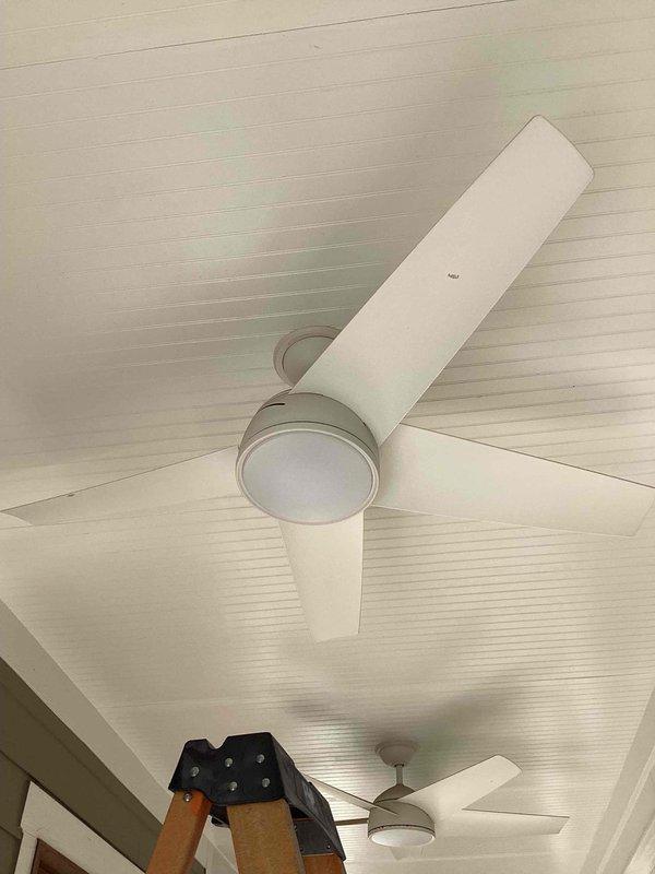 Responded to service call for ceiling fan replacement at residence built in 2005. Customer had three Minka Air outdoor ceiling fans with one unit requiring replacement. Verified electrical panel configuration and existing wiring to ensure compatibility between new replacement fan and two existing operational units previously installed. Confirmed that new Minka Air model could be integrated with current wiring system and would operate in conjunction with remaining fans. Inspected flush-mount ceiling fan installation on beadboard ceiling, verified proper electrical connections, and documented electrical panel showing organized circuit breaker layout with appropriate wire gauging and connections. Ensured all three fans would function properly on existing circuit with compatible controls.