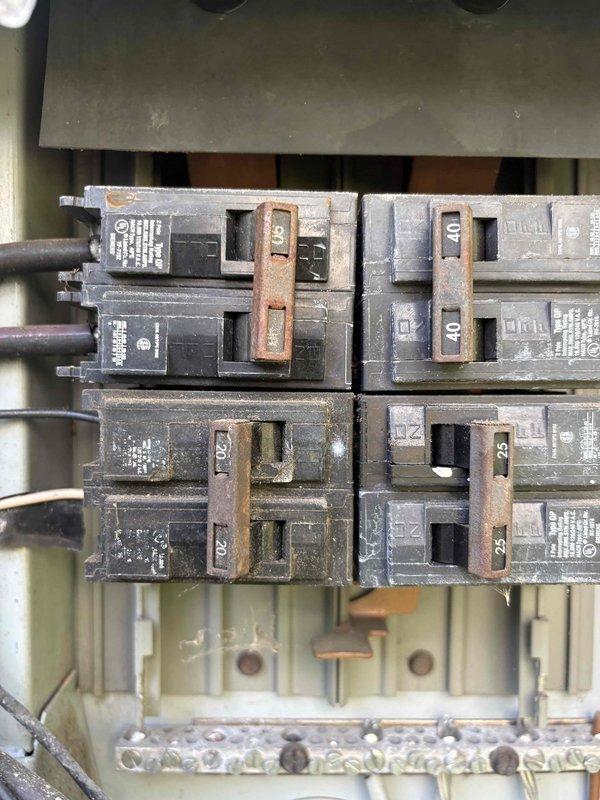Responded to no cooling complaint on downstairs system installed in 2020. Upon arrival, homeowner reported unit was blowing warm air with no cold air output and had system turned off for several hours. Inspection revealed significant dust and debris accumulation in blower assembly and ductwork components, along with corroded electrical connections and oxidized bus bars in associated electrical panel showing signs of age and moisture exposure. Documented equipment condition with photos of compromised electrical components and heavily soiled HVAC interior requiring attention to restore proper system operation and ensure safe electrical connections.