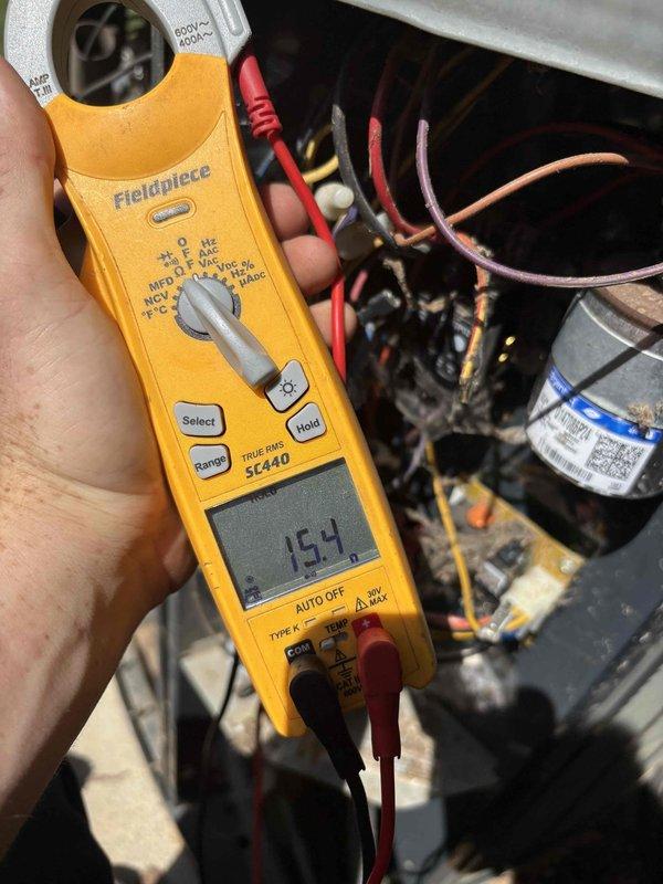 Responded to no cooling call on downstairs unit of a two-system residence with 9-10 year old equipment. Found evaporator coil heavily frosted, indicating restricted airflow or refrigerant issue. Measured compressor amperage at 154 amps using clamp meter and inspected electrical connections and control wiring. Unit was not operating despite customer's prior attempt to clear drain line, confirming issue was related to frozen coil condition rather than safety float switch activation.