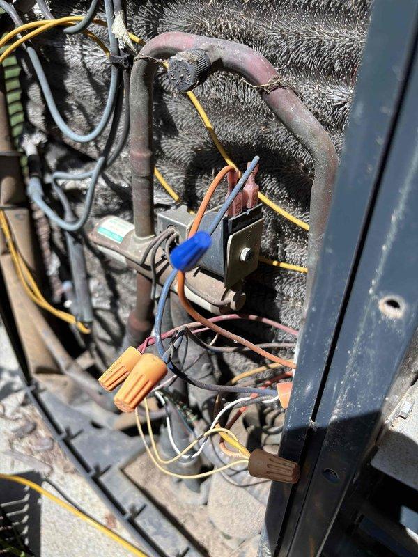 Responded to no cooling call on downstairs unit of a two-system residence with 9-10 year old equipment. Found evaporator coil heavily frosted, indicating restricted airflow or refrigerant issue. Measured compressor amperage at 154 amps using clamp meter and inspected electrical connections and control wiring. Unit was not operating despite customer's prior attempt to clear drain line, confirming issue was related to frozen coil condition rather than safety float switch activation.