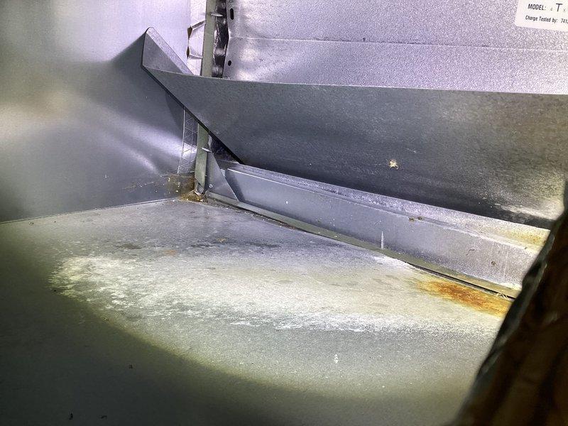 # HVAC Supply Plenum Re-Insulation

Accessed the air handler unit to assess the supply plenum insulation condition. Upon inspection, found deteriorated and compromised insulation material on the supply plenum, with evidence of moisture infiltration and general wear from prolonged operation. The blower assembly and interior metal surfaces showed dust accumulation and discoloration, with visible water staining on the base pan indicating previous condensation issues.

Removed old insulation material from the supply plenum. Cleaned interior metal surfaces to ensure proper adhesion of new insulation. Re-insulated the supply plenum with appropriate R-value insulation material to restore thermal efficiency and prevent condensation formation. Verified all seams and joints were properly sealed to maintain system efficiency and prevent air leakage. Confirmed blower wheel and fan components remained unobstructed and operational throughout the process.