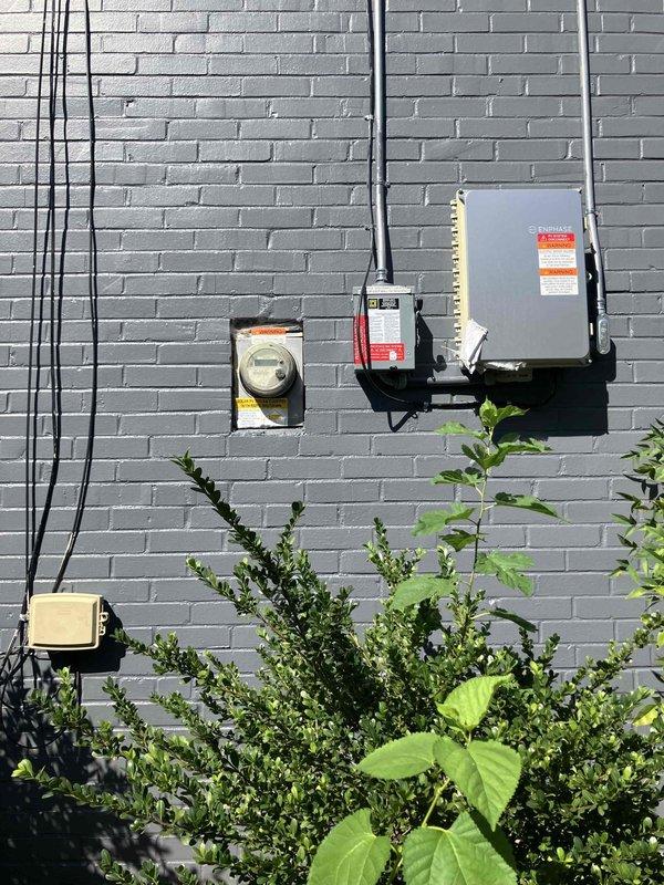 Responded to service call at 1940s residential property with electrical updates completed approximately 10 years prior. Performed comprehensive assessment of three primary electrical concerns: non-functioning outdoor outlet on west side of structure, request for new ceiling fan circuit installation at front porch, and feasibility evaluation for tankless electric water heater conversion.

Inspected exterior electrical service equipment mounted on west-facing gray brick wall, including main service panel, meter base, and associated conduit runs. Evaluated existing electrical service capacity and panel configuration to determine load availability for proposed upgrades. Documented current electrical panel with dual columns of circuit breakers, noting available breaker spaces and existing circuit distribution.

Troubleshot inoperative outdoor GFCI receptacle on west exterior wall. Tested circuit continuity, verified ground fault protection functionality, and identified failure point. Assess