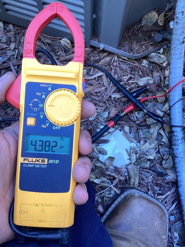 Responded to no cooling complaint on 9-year-old residential air conditioning system. Customer reported unit unable to achieve desired temperature, only reaching 74-75°F during day with no improvement at night over past several days. Upon arrival, performed diagnostic testing of outdoor condensing unit. Used clamp meter to measure electrical parameters including frequency (43.82 Hz) and capacitance (32.50 µF) at the condenser. Measurements indicated potential capacitor degradation affecting compressor performance and overall cooling capacity. Documented findings with photos of electrical readings and equipment condition for service records.