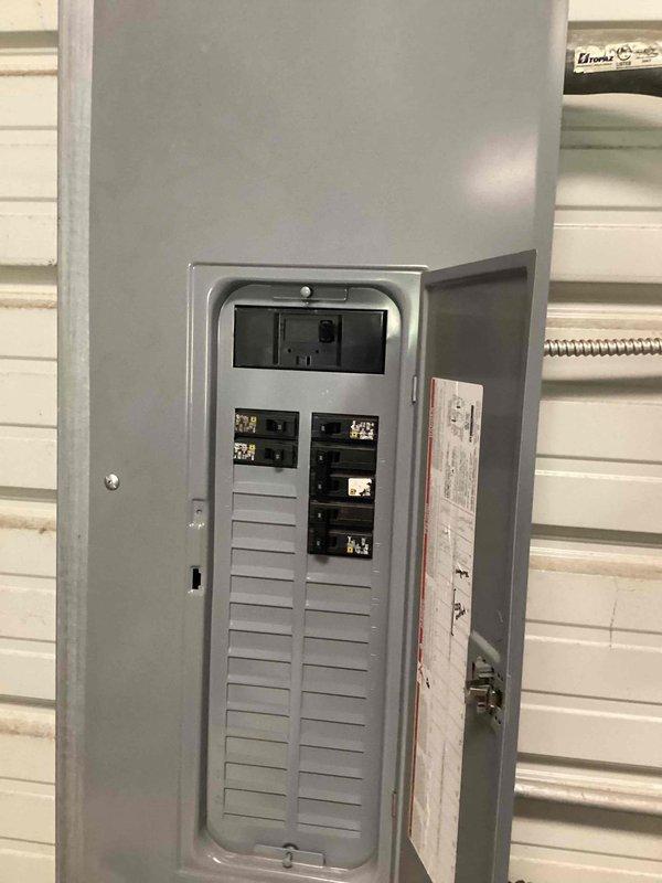Responded to report of flickering lights in detached garage/storage building with increased usage. Inspected electrical panel serving the structure and verified proper breaker operation with no tripped circuits. Evaluated fluorescent light fixtures mounted throughout the space and assessed electrical connections at the panel box. Determined that increased electrical load from additional garage usage may be contributing to voltage fluctuations affecting the lighting circuits.