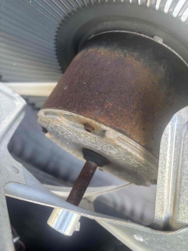 Responded to no cooling complaint with warm air from vents on a 5-year-old single system. Upon inspection, found severely corroded condenser fan motor with extensive rust and oxidation affecting operation, along with control board wiring requiring assessment. Diagnosed failed outdoor fan motor as primary cause of inadequate cooling performance.