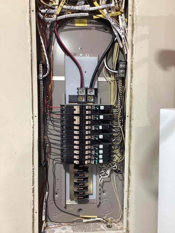 Responded to service call for flickering lights upstairs and beeping smoke detectors in 2012 residential property. Inspected main electrical panel and found no loose connections, damaged breakers, or wiring issues; all circuits properly secured and functioning within normal parameters. Tested smoke detector circuit and determined beeping was due to end-of-life sensors requiring replacement rather than electrical fault; advised homeowner of detector replacement needs and confirmed flickering likely isolated to specific fixture or switch requiring further investigation at light locations.