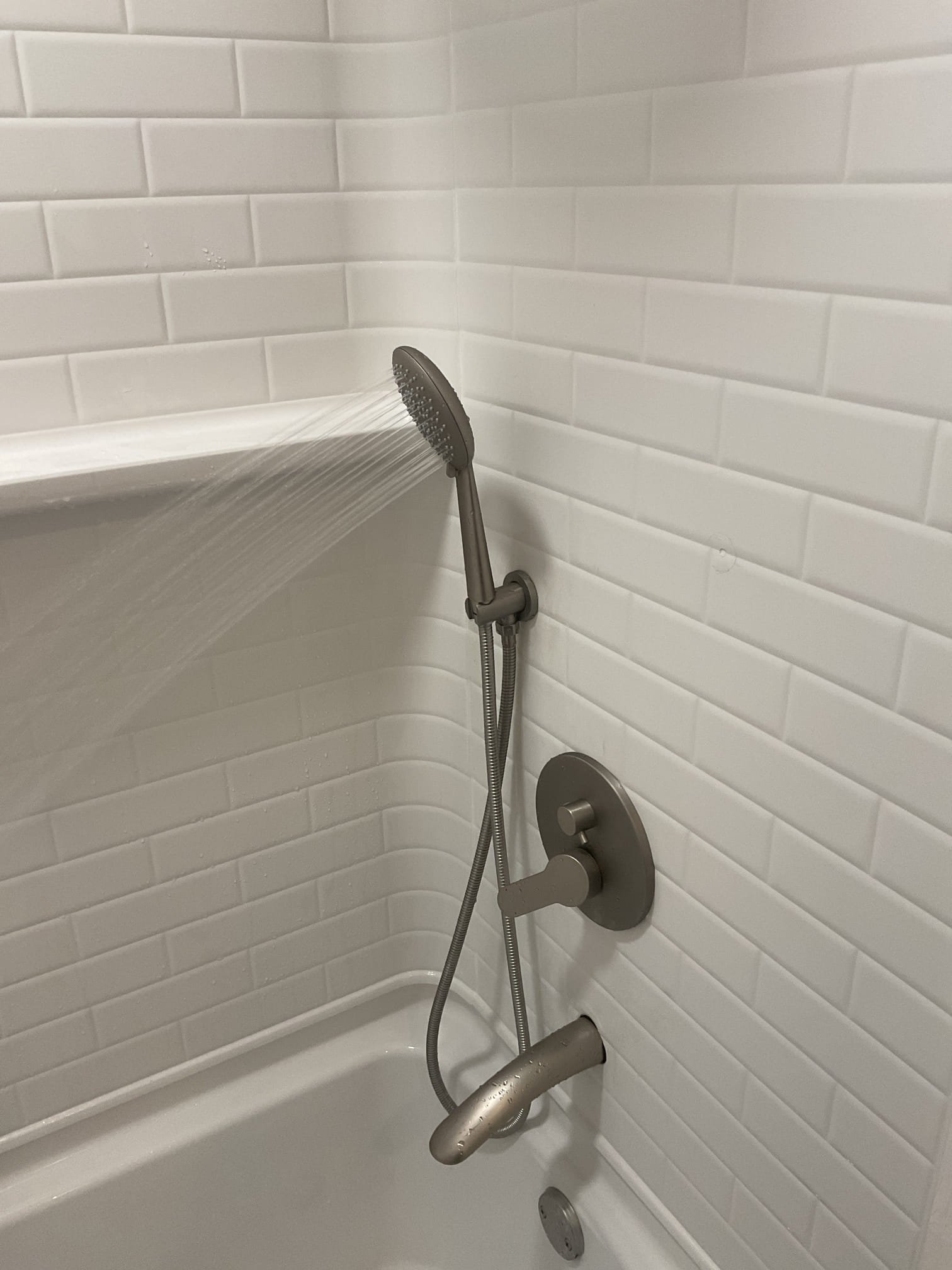 Removed the existing shower valve and installed a new homeowner-supplied 3-way shower valve with rain head, side sprayer, and tub spout. Added necessary blocking to securely support the valve, sprayer, shower head, and tub spout, ensuring solid and reliable operation.

Per homeowner request, the old shower bar was removed after advising that removal would leave two visible screw holes. The homeowner chose to have the holes filled with silicone only.

Noted that the previous plumber had drilled two holes for the tub spout and left a large gap filled with silicone. Assisted the homeowner in selecting a suitable tub spout finish ring to cover the exposed area (as shown in photos). The homeowner has ordered the part and will install it upon arrival.

