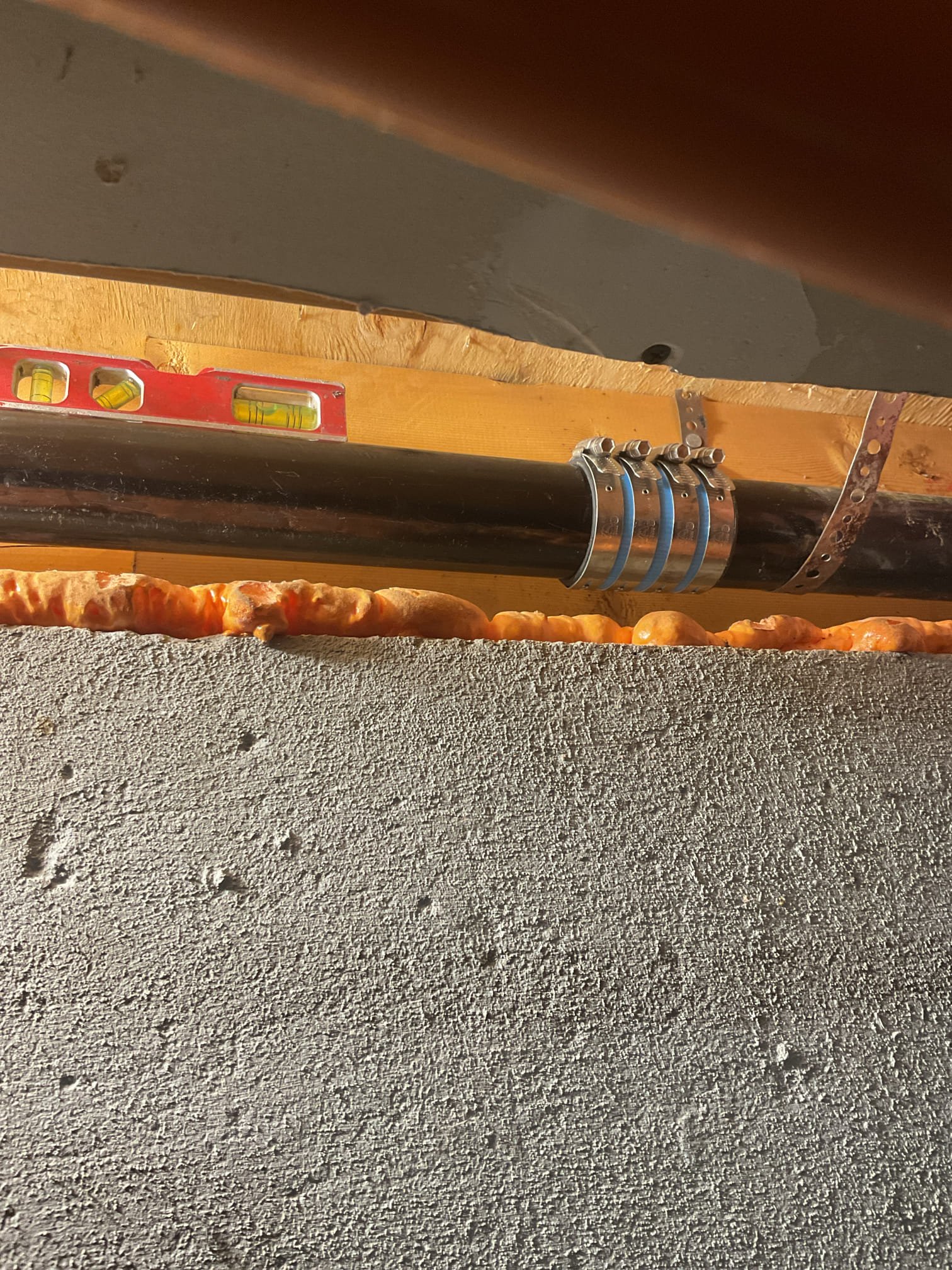 Kitchen Drain Line Repair:
-A section of the kitchen drain line was replaced due to ongoing leaks and repeated clogging issues. The existing 2" ABS drain exhibited significant back-pitch and had been previously patched with PVC, which failed to bond correctly and resulted in additional leakage.
-Approximately 20 feet of Sheetrock was removed to access the affected piping. All insulation within the repair area was removed and stored in the garage for reinstallation. Only one pipe hanger was found supporting this length of pipe, with the beam serving as the only additional structural support.
-Twenty feet of ABS piping was cut out and removed. Sections of the line were found to be completely filled with standing water and food grease. -New blocking was installed every four feet to properly support the replacement pipe and ensure correct pitch.
-The new line was tied into the existing pipe coming through the floor using a standard 90° fitting due to pitch limitations. The replacement sect