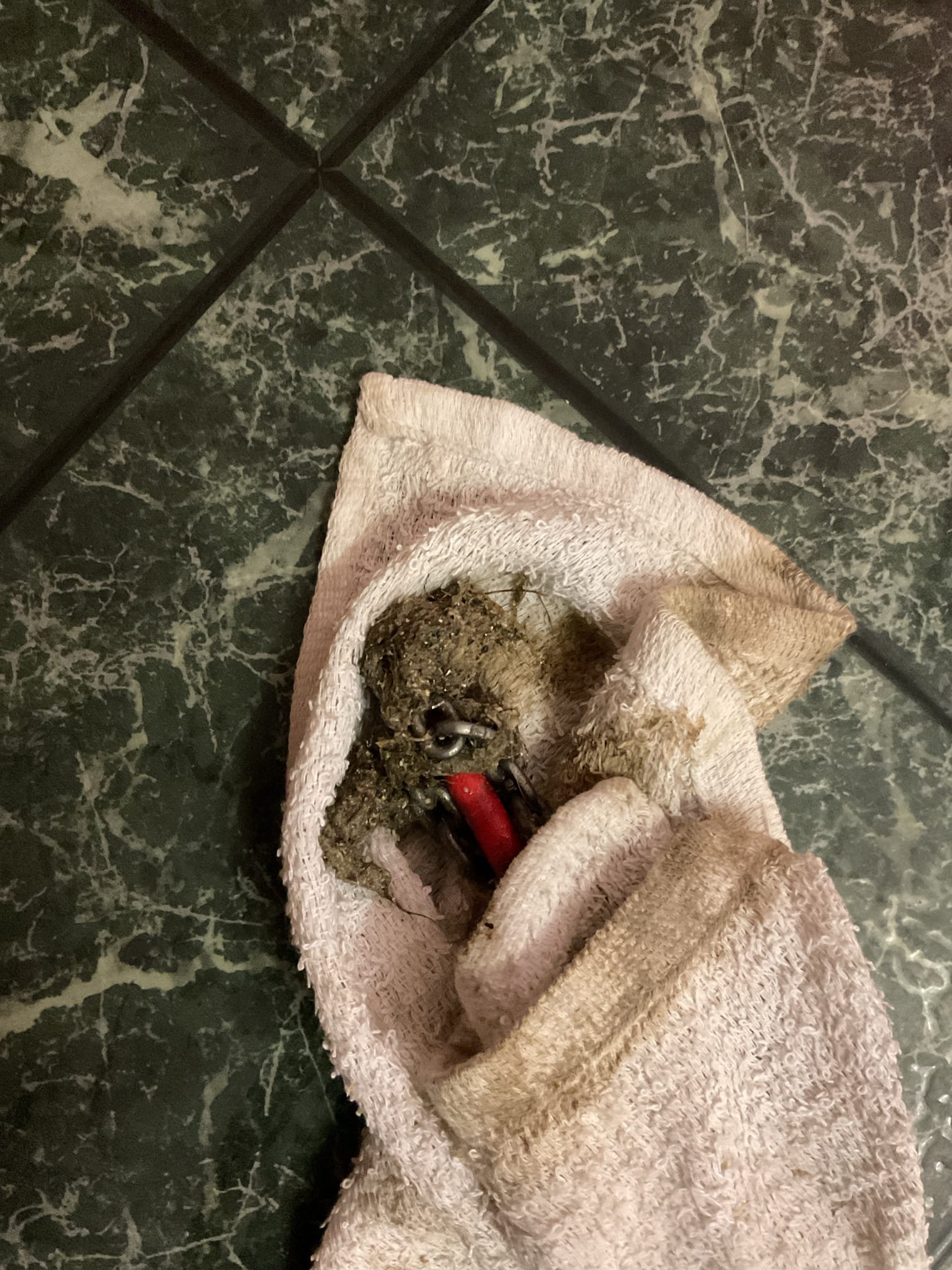 I was called to a home to fix a slow-draining kitchen sink. Upon inspection, I found that the kitchen drain was clogged and needed to be snaked. While snaking the drain, I noticed that the dishwasher tailpiece was hanging on by a thread. I also noticed that the gasket was deformed. To resolve the issue, I installed a new dishwasher tailpiece and re-assembled the drainage. After snaking and re-assembling the drainage, I tested for proper operation and drainage, and there were no leaks observed at this time.