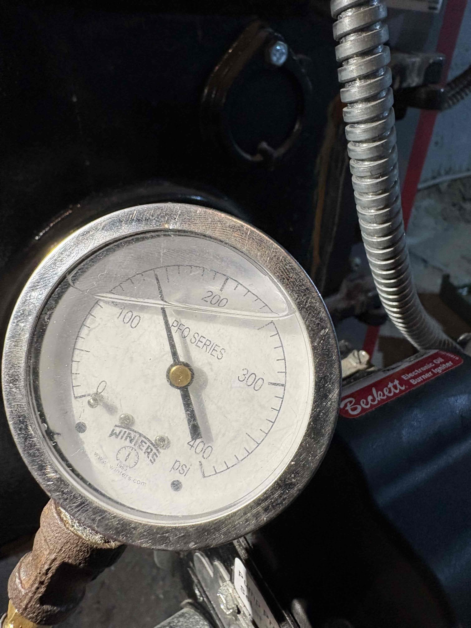 Arrived on scene for a report of the upstairs zone not working. Upon arrival, the upstairs zone was operating properly and circulating hot water. Amanda reported an additional concern about an intermittent chime or alarm-like sound that she believed might be coming from a safety device. I was unable to clearly hear the noise, and we could only briefly recreate it right after the boiler shut off. Based on the timing and tone, I believe the sound may be originating from the chimney, which was serviced in May 2025. I secured a loose pipe hanger and checked all hydronic components but could not identify the source of the sound. I also noted that the tridicator gauge is reading approximately 10 psi higher than the actual boiler pressure.

I performed annual maintenance on the Advantage oil boiler, including replacing the nozzle, oil filter, and pump strainer. I brushed and vacuumed the heat exchanger and flue pipe and found bird debris inside the heat exchanger, increasing my suspicion that