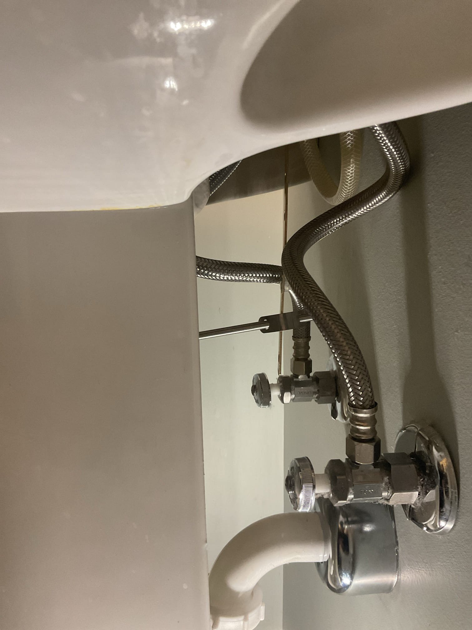 Lavatory Pop-Up Assembly Replacement – Upstairs Bathroom:
The lavatory pop-up assembly was found to be heavily corroded around the drain base and cap. We recommended replacement to ensure a proper seal, prevent leaks, and restore reliable drainage. Water was shut off and the drainage disconnected, then the pedestal top was removed to complete the repair. The existing pop-up was removed and surfaces were cleaned thoroughly. A new pop-up assembly was installed using plumber’s putty and thread sealant, and fittings were tightened securely. The trap was partially pre-assembled due to limited space, and the pedestal top was reset with new wall anchors and a bead of caulk at the base. The p-trap was reassembled and new braided supply lines were installed. The system was tested with water on, confirming proper operation with no leaks present at this time.

Lavatory Replacement Recommendation – Downstairs Bathroom:
The downstairs bathroom pop-up assembly was not functioning, preventing proper 