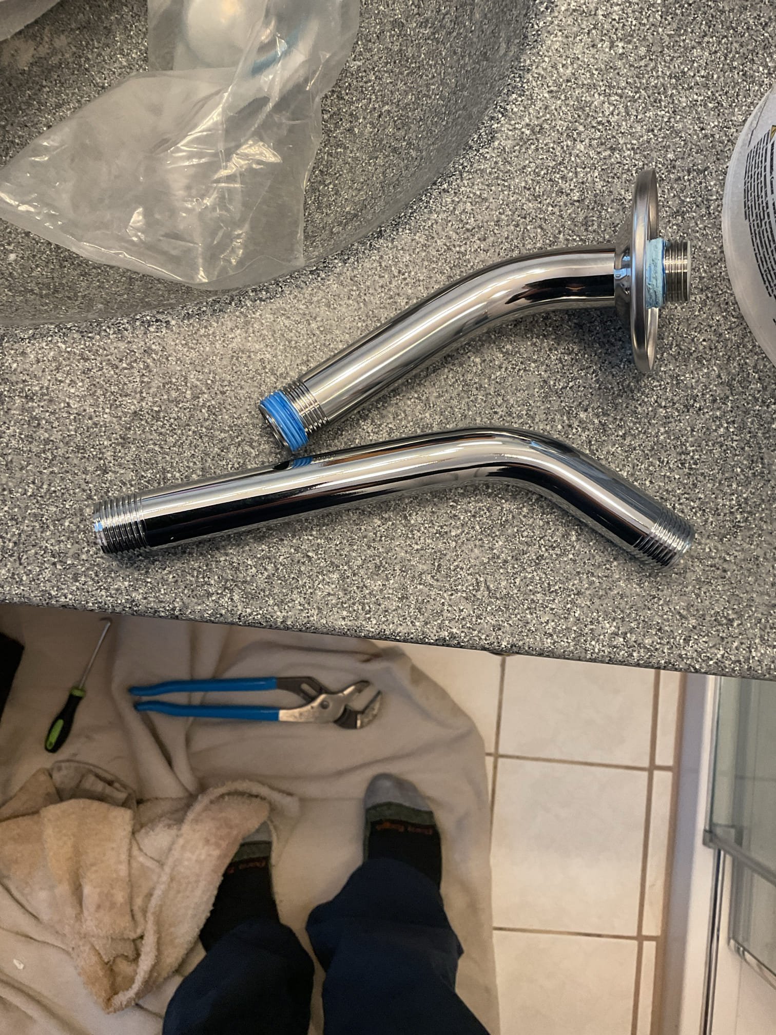 Replaced the shower arm with an 8” long shower arm and applied another layer of sealant along the bottom of the fixed glass panel. 